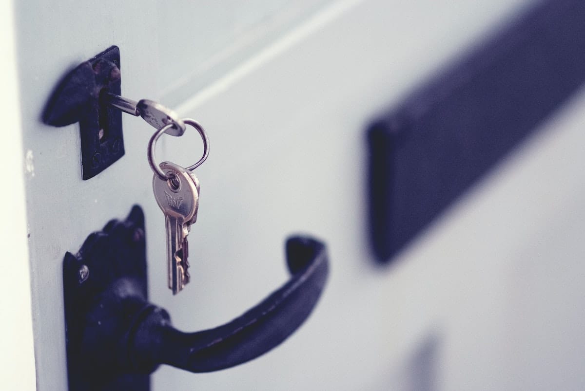 Keys in a lock against a white door